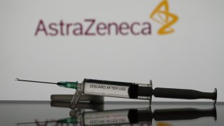 In this photo illustration a covid-19 vaccine is seen with the AstraZeneca logo in the background. (Photo Illustration by Nikos Pekiaridis/NurPhoto via Getty Images)