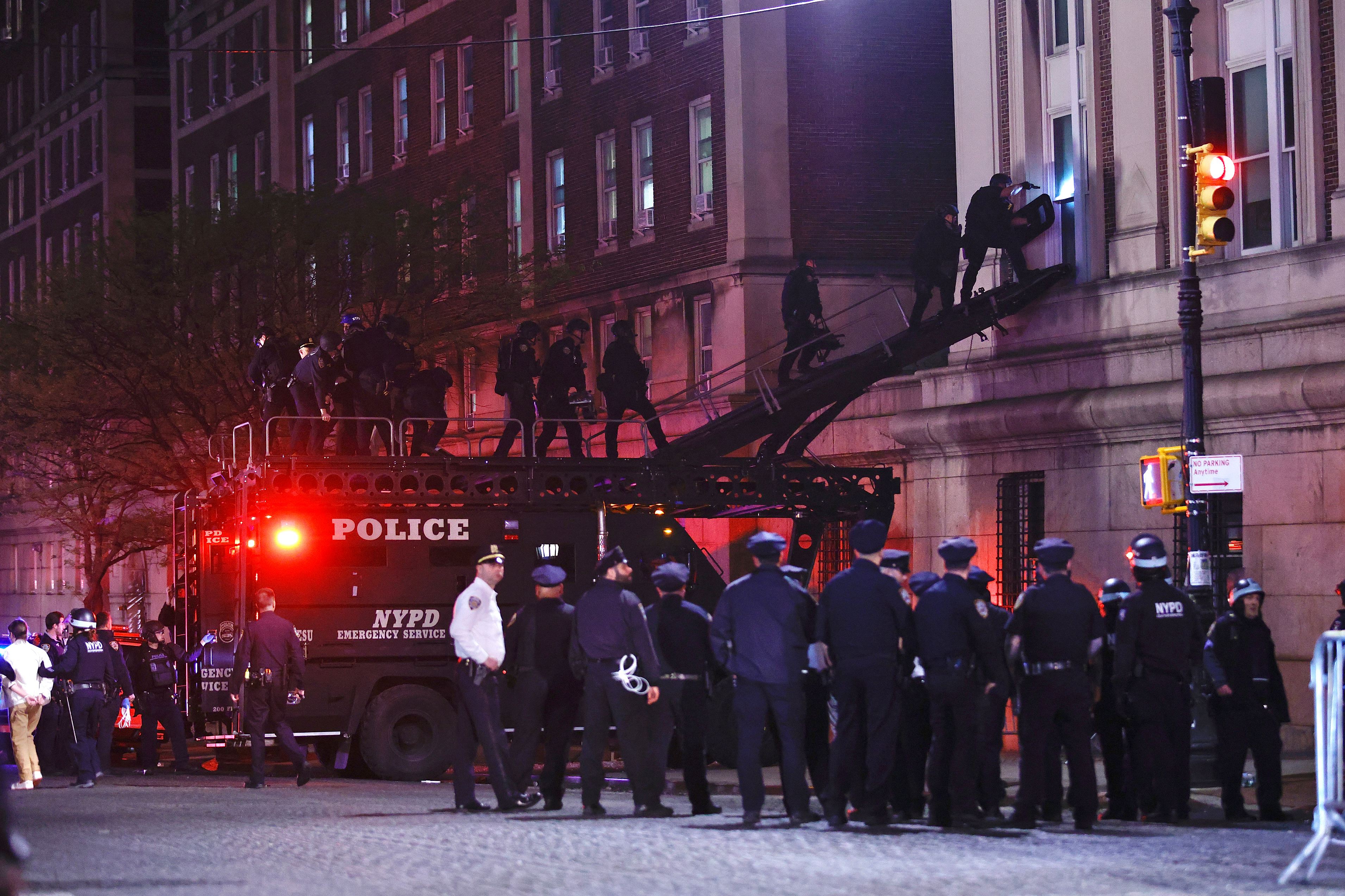 NYPD officers in riot gear break into a building at Columbia University, where pro-Palestinian students are barricaded inside, on April 30, 2024 in New York.