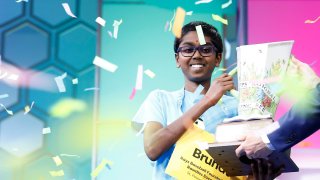 Twelve-year-old Bruhat Soma, of Tampa, Florida, is handed the Scripps Cup after winning the 2024 Scripps National Spelling Bee at the Gaylord National Resort and Convention Center on May 30, 2024 in National Harbor, Maryland.