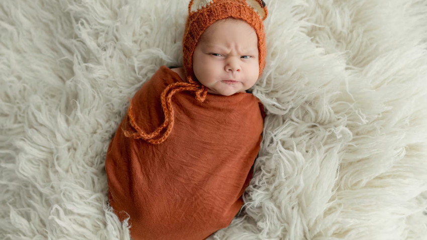 A baby making a face at the camera.