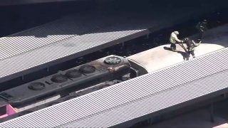 Firefighters atop an MBTA train engine where a fire was reported Friday, May 10, 2024, at Boston's North Station.