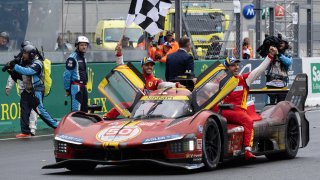 Ferrari 499P Hybrid Hypercar WEC’s team, Spanish driver Miguel Molina (R) Italian driver Antonio Fuoco (C) and Danish driver Nicklas Nielsen (in the car) celebrate after winning Le Mans 24-hours endurance race in Le Mans, western France, on June 16, 2024.