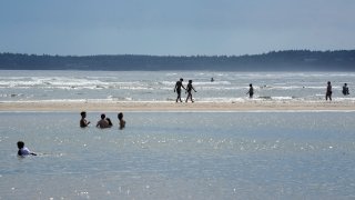 PHIPPSBURG, ME – JULY 30: People walk in the shallow water at Popham Beach State Park in Maine. (Staff Photo by Gregory Rec/Portland Press Herald via Getty Images)