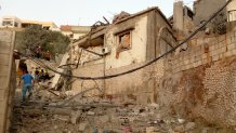 A Lebanese man walks past destroyed homes