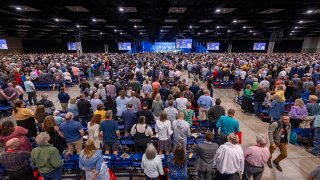 Messengers stand for worship during a Southern Baptist Convention annual meeting Tuesday, June 11, 2024, in Indianapolis.