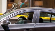 A balloon that reads, "Congrats grad!" in a car that's surrounded by police tape in Boston's Seaport District after a shooting Thursday, June 13, 2024. An 18-year-old woman who'd attended her high school nearby was wounded, police said.