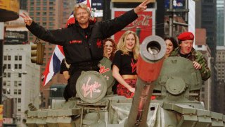 Richard Branson (L), chairman of Virgin, waves as he rides a tank into New York’s Times Square to promote the United States launch of Virgin Cola, May 12. Virgin Cola was introduced in the United Kingdom in 1994, and is also available in several other European countries.