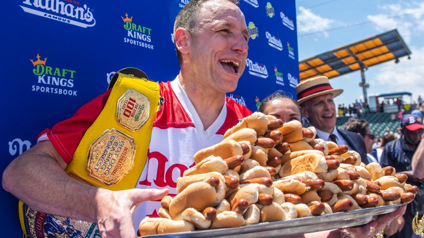 FILE – Joey Chestnut, winner of the 2021 Nathan’s Famous Fourth of July International Hot Dog-Eating Contest, poses for photos in Coney Island’s Maimonides Park, July 4, 2021, in the Brooklyn borough of New York.  Chestnut will take his hot dog-downing talents to an army base in Texas for America’s Independence Day this year, after a falling out with organizers of the annual New York City-based event.