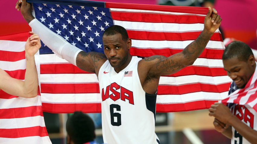 LeBron James holds the American flag over him at the 2012 Olympics