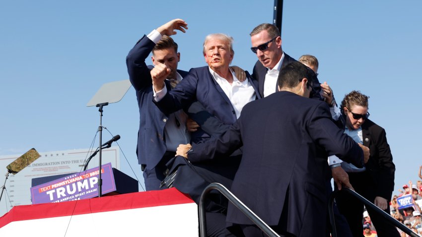 BUTLER, PENNSYLVANIA – JULY 13: Republican presidential candidate former President Donald Trump is rushed offstage during a rally on July 13, 2024 in Butler, Pennsylvania. Butler County district attorney Richard Goldinger said the shooter is dead after injuring former U.S. President Donald Trump, killing one audience member and injuring another in the shooting.