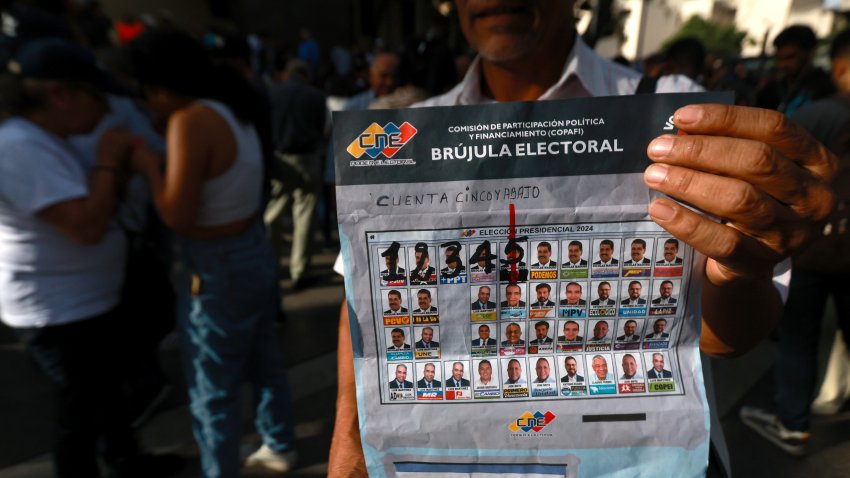 CARACAS, VENEZUELA – JULY 21: A man shows a facsimile of what will be the presidential elections ballot at Bolivar Square on July 21, 2024 in Caracas, Venezuela. The opposition leader of the political movement ‘Vente Venezuela’ MarÌa Corina Machado and the candidate Edmundo Gonzalez Urrutia hold a day of prayer for Venezuela before the elections. (Photo by Jesus Vargas/Getty Images)