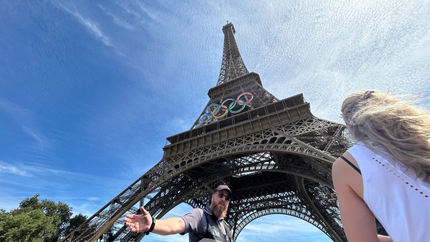 Police evacuate the area around the Eiffel Tower after a man was seen climbing the historic landmark, during the 2024 Summer Olympics, Sunday, Aug. 11, 2024, in Paris France. (AP Photo/Aijaz Rahi)