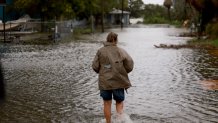 CEDAR KEY, FLORIDA - AUGUST 05:  A person walks through a flooded street caused by the rain and storm surge from Hurricane Debby on August 05, 2024, in Cedar Key, Florida. Hurricane Debby brings rain storms and high winds along Florida’s Big Bend area.  (Photo by Joe Raedle/Getty Images)