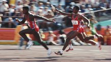 Calvin Smith passes the baton to teammate Carl Lewis in the 4x100m relay during the 1984 Olympic Games.