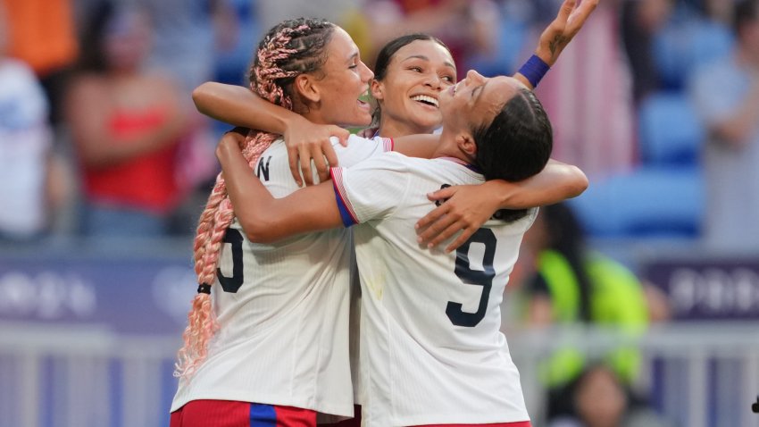 Team USA women's soccer team hugs on field