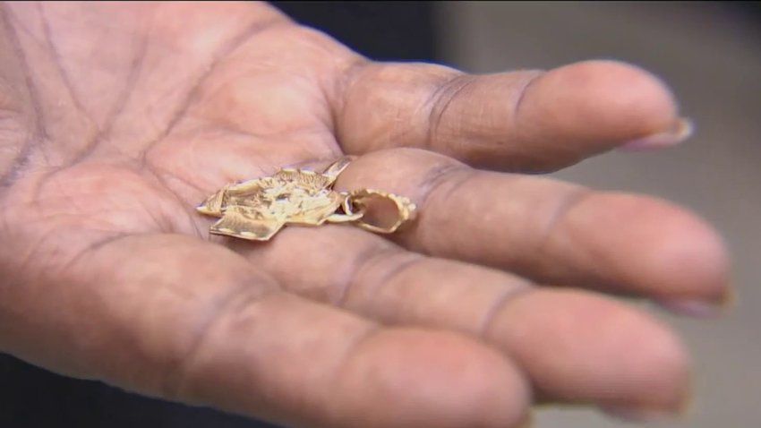 A gold pendant in a woman's hand