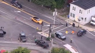 Aerial view of an intersection with police cars blocking off a crosswalk area