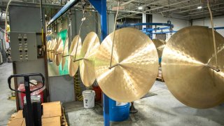 Cymbals hang awaiting a coating process.