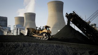 A bulldozer moves coal that will be burned to generate electricity at the American Electric Power coal-fired power plant in Winfield, West Virginia.