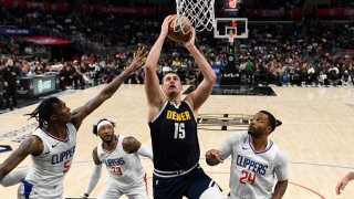 Nikola Jokic, #15 of the Denver Nuggets, shoots the ball against Bones Hyland, #5, and Norman Powell, #24, of the Los Angeles Clippers during the second half of a preseason game at Crypto.com Arena in Los Angeles on October 19, 2023.