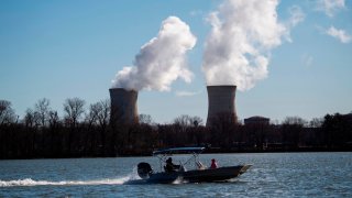 A boat passes the nuclear plant on Three Mile Island as seen from Goldsboro, Pennsylvania, with the operational plant run by Exelon Generation, across the Susquehanna river in Middletown, Pennsylvania on March 26, 2019. 