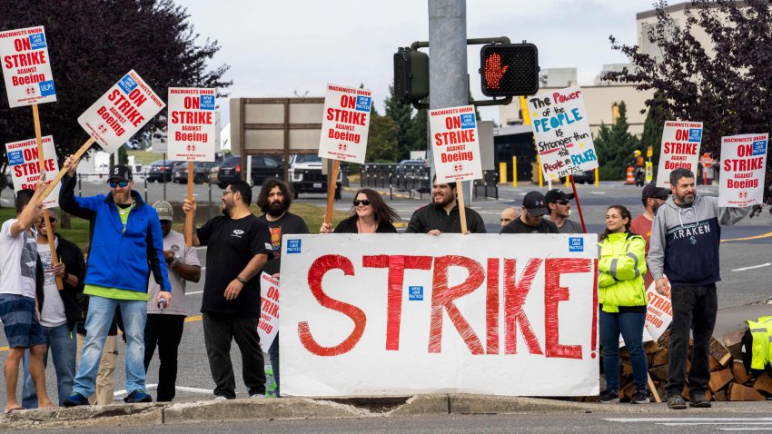 Workers with picket signs outside the Boeing Co. manufacturing facility during a strike in Everett, Washington, US, on Friday, Sept. 13, 2024. 