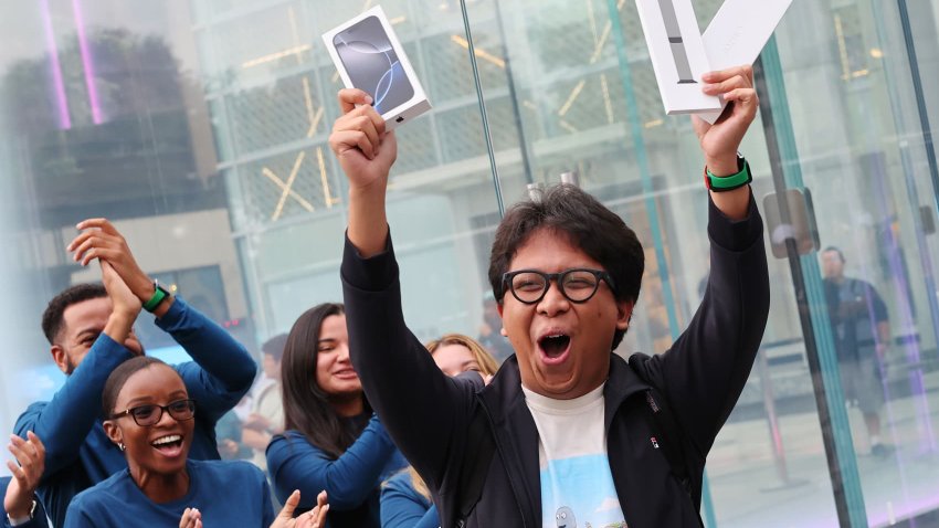 The first customer to purchase the new iPhone16 celebrates as he exits the Fifth Avenue Apple Store on new products launch day on September 20, 2024 in New York City. 