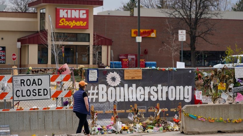 Tributes cover the temporary fence around the King Soopers grocery store in which 10 people died in a mass shooting.