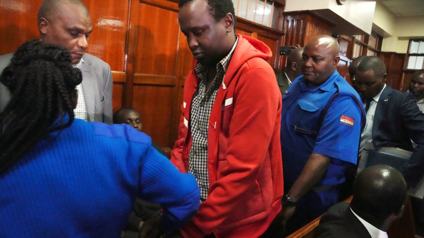 Kevin Adam Kinyanjui Kangethe is escorted out of the courtroom at the Milimani law court in Nairobi, Kenya