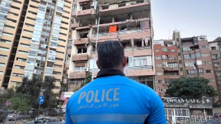 A Lebanese policeman looks at damaged apartments that were hit by Israeli strike early Monday, Sept. 30, 2024, in Beirut, Lebanon.