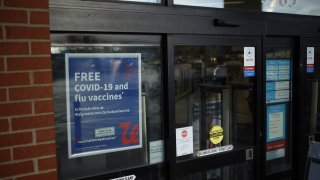 A sign offers customers free Covid-19 and flu vaccines at a Walgreens location in Louisville, Kentucky, U.S., on Thursday, March 24, 2022.