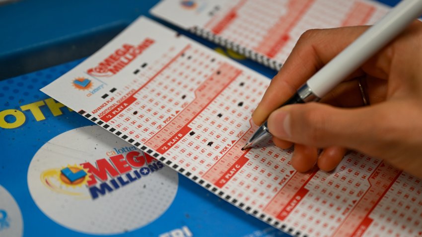 A person plays Mega Millions lottery at a 7-Eleven in Redwood City