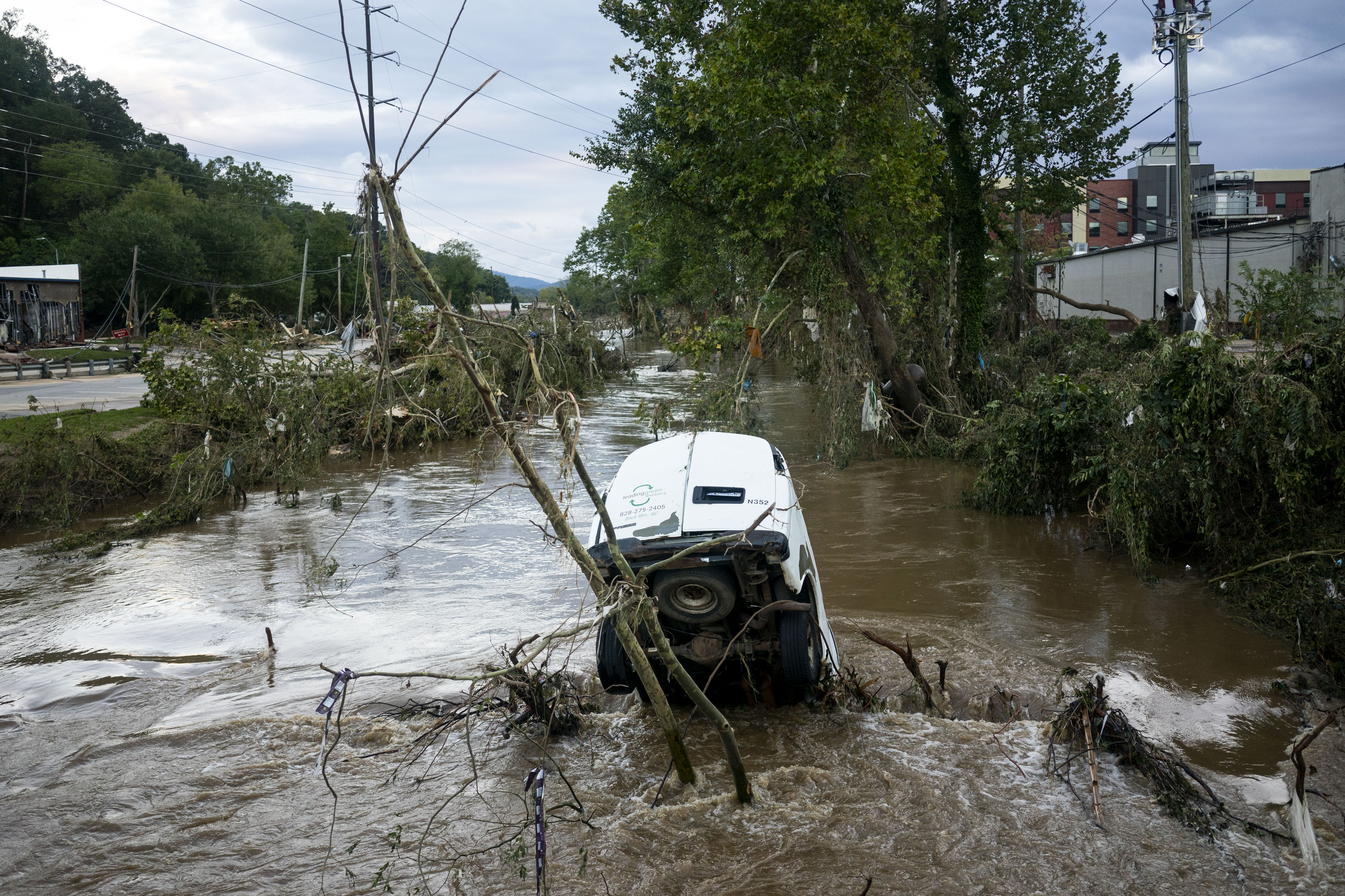 A van is partially submerged in the Swannanoa River in the  Biltmore Village in the aftermath of Hurricane Helene on September 29, 2024 in Asheville, North Carolina.