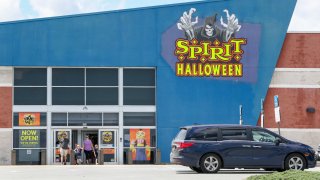 A family exits a Spirit Halloween store operating in a former Best Buy. 