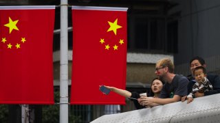 People observe the scenery near Chinese national flags displayed for National Day celebrations on October 3, 2024 in Chongqing, China. National Day Golden Week is a holiday in China commemorates the founding of the People’s Republic of China in 1949. 