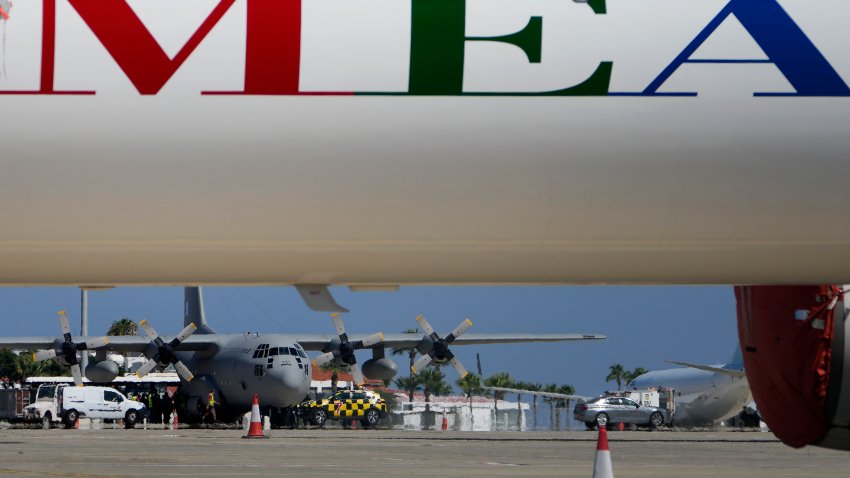 A Greek military transport aircraft carrying Greek and Cypriot citizens evacuated from Lebanon, is seen behind an MEA airlines, after it landed at Larnaca airport, Cyprus, on Thursday, Oct. 3, 2024.