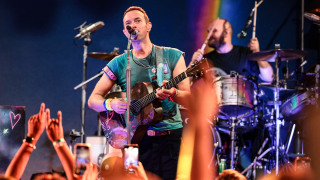 Coldplay's Chris Martin plays guitar on stage