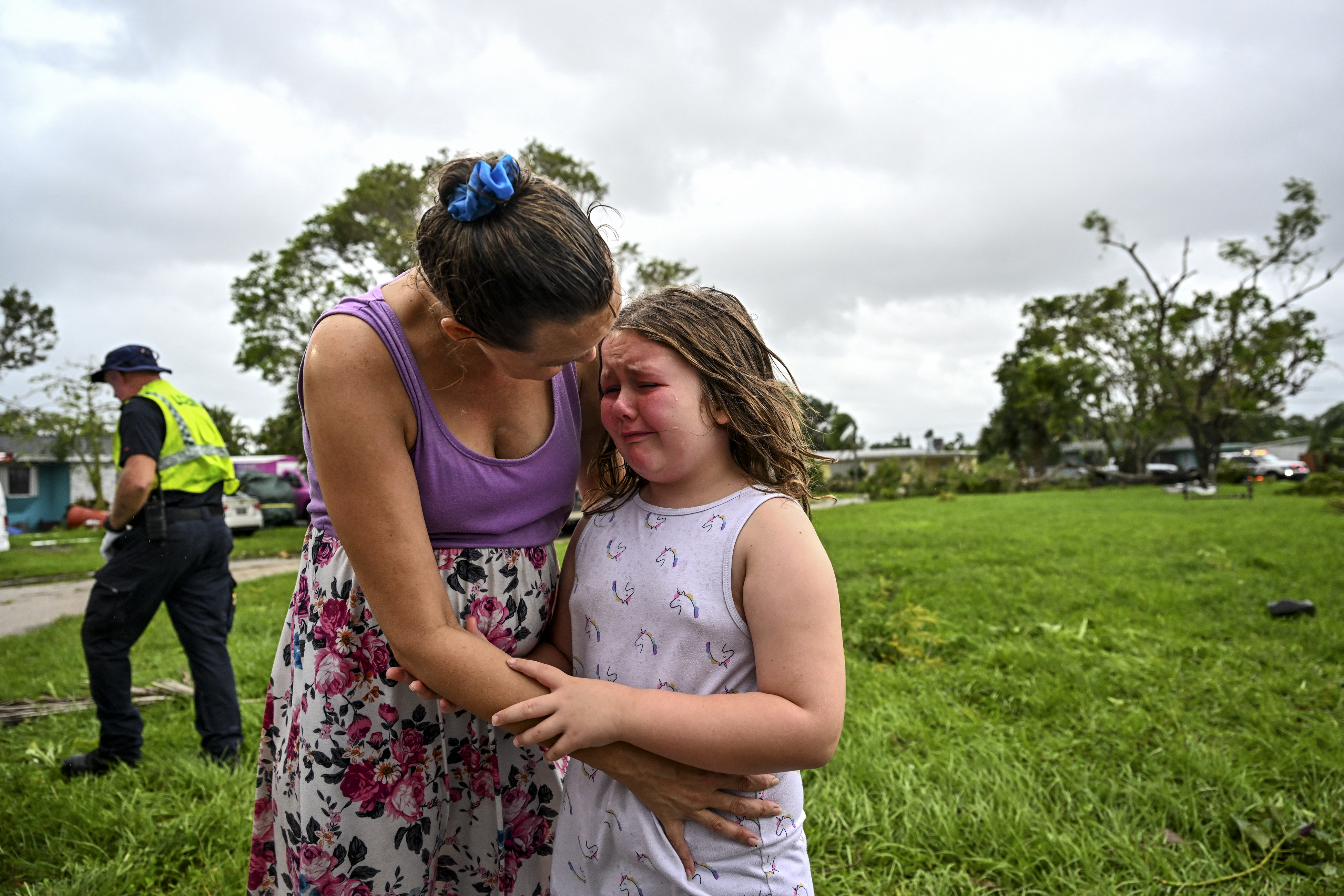 Samantha Dubberly consoles her daughter Alexa Haight as medics takes her grandfather into care after he got injured by a reported tornado that hit his house in Fort Myers, Florida on October 9, 2024, as Hurricane Milton approaches.