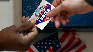 A voter receives a Las Vegas-themed “I Voted” sticker after casting their ballot inside the Galleria at Sunset mall on November 05, 2024 in Las Vegas, Nevada.