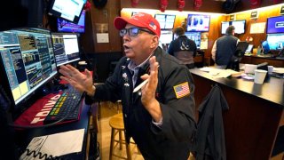 Trader Jonathan Mueller wears a Trump hat as he works on the floor of the New York Stock Exchange (NYSE) at the opening bell on November 6, 2024, in New York City. 