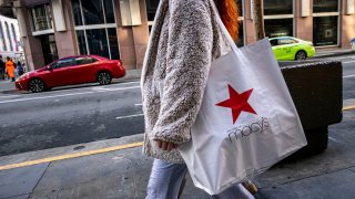 A shopper carries a Macy’s bag on Market Street in San Francisco, California, US, on Wednesday, Nov. 13, 2024. 