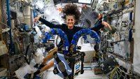 Suni Williams checks out the Astrobee robotic free-flyer on the International Space Station on Nov. 15. The device is outfitted with tentacle-like arms containing gecko-like adhesive pads to demonstrate satellite capture techniques.