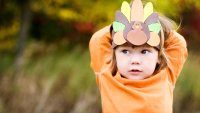 A little boy with a Turkey hat.