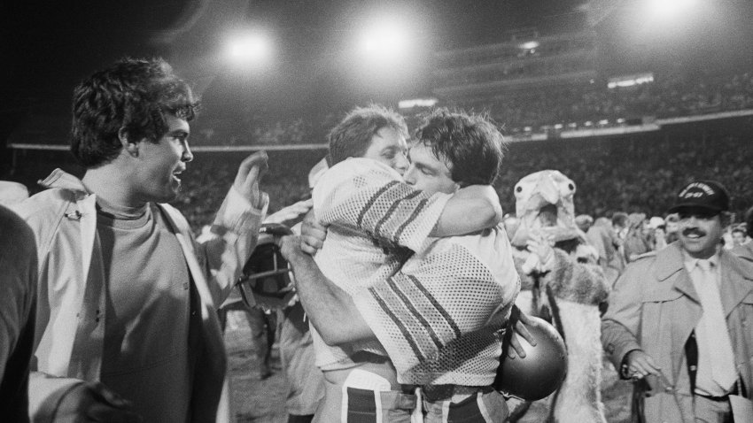 Boston College quarterback Doug Flutie (R) hugs a teammate after beating the Hurricanes 47-45 in the final six seconds of the game on November 23, 1984.