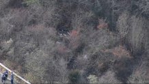 An overturned vehicle off a ramp to I-95 in Boxford, Massachusetts, on Wednesday, Nov. 27, 2024, with state police nearby.