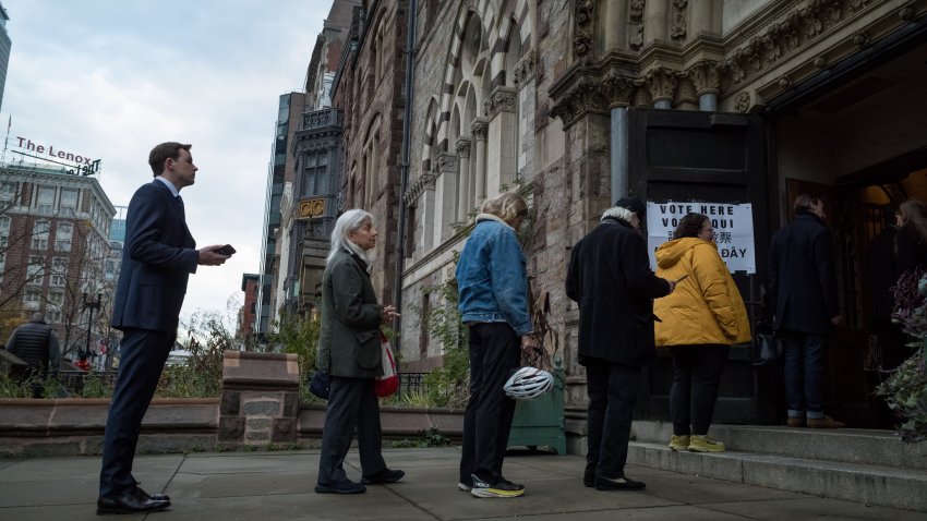 Massachusetts voters wait in line as polls open at 7 a.m. on Boylston St. in Boston