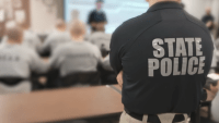 A file photo showing a person in a state police shirt at the back of a class