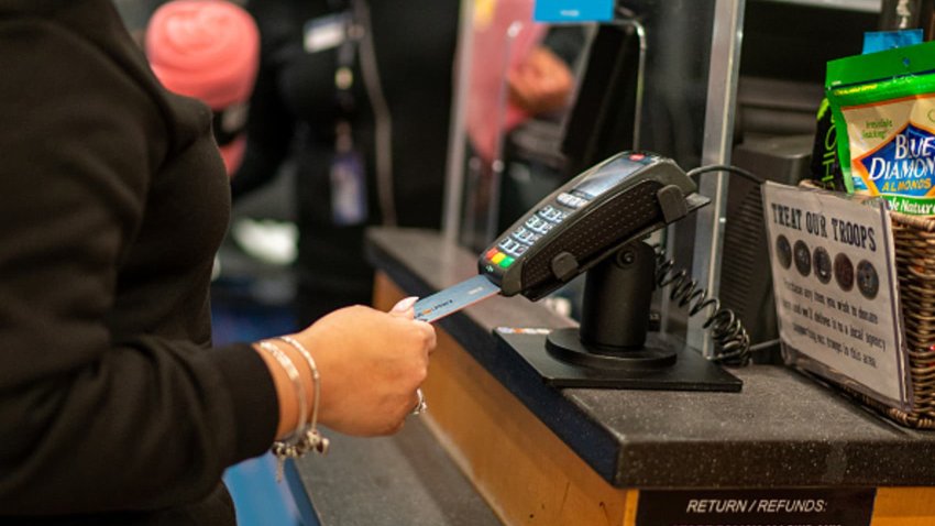 A customer uses a credit card to pay for items January 28, 2022 at a retail shop in New York City. 