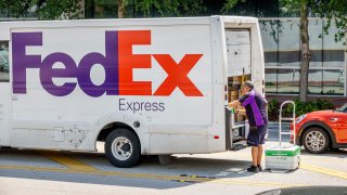 Miami Beach, Florida, FedEx Express delivery van parked, driver unloading box dolly. 