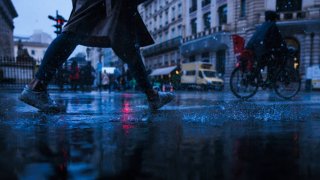 A pedestrian crosses a flooded street following heavy rainfall in Paris on October 17, 2024.